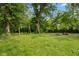 Backyard with a swing set, fire pit, mature trees, and green grass at 150 Church St, Mooresville, IN 46158