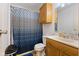 Cozy bathroom featuring a wooden vanity, toilet, and shower with decorative blue curtain at 150 Church St, Mooresville, IN 46158