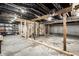 Unfinished basement featuring exposed beams, ductwork, and a framed stairway at 1509 S Spencer Ave, Indianapolis, IN 46203