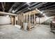 Unfinished basement framed with stairs, showing exposed pipes and unfinished flooring at 1509 S Spencer Ave, Indianapolis, IN 46203