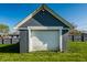 A well-maintained garage features a fresh white door and painted walls, set against a lush green lawn at 1509 S Spencer Ave, Indianapolis, IN 46203