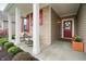 Inviting front porch featuring red door, rocking chairs, and beautiful landscaping at 16201 Haywood St, Fishers, IN 46037