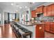 Open kitchen featuring cherry cabinets, granite counters, stainless appliances, and a breakfast bar at 16201 Haywood St, Fishers, IN 46037