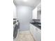 Well-lit laundry room with white front load washer and dryer, cabinetry and wash basin at 16201 Haywood St, Fishers, IN 46037