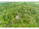 A high-angle shot captures multiple cabins with roofs and parking in a dense green forest at 1630 Hinson Rd, Martinsville, IN 46151