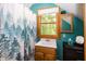 Cozy bathroom features a window, sink with cabinet, and a charming shower with a forest-themed curtain at 1630 Hinson Rd, Martinsville, IN 46151