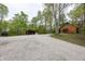 Exterior view of a charming log cabin with a gravel driveway and shed at 1630 Hinson Rd, Martinsville, IN 46151