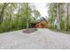 Charming log cabin exterior with a gravel driveway and a backdrop of lush green trees at 1630 Hinson Rd, Martinsville, IN 46151