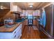 A rustic kitchen features wood-paneled walls, wood floors, wooden cabinets, and stainless steel appliances at 1630 Hinson Rd, Martinsville, IN 46151