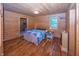 Cozy main bedroom with wood-paneled walls, hardwood floors, and a comfortable bed at 1630 Hinson Rd, Martinsville, IN 46151