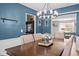 Dining room with modern chandelier, a blue accent wall and a wooden table at 18811 Orleans Ct, Noblesville, IN 46060