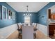 Dining room featuring chair railing, blue walls, a light fixture and a wooden table at 18811 Orleans Ct, Noblesville, IN 46060