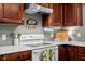 Kitchen featuring a white stove, countertop and dark brown cabinets at 18811 Orleans Ct, Noblesville, IN 46060