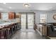 Open-concept living room with kitchen bar, sliding glass door and gray tile floors at 18811 Orleans Ct, Noblesville, IN 46060
