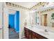 Bright bathroom features double sinks, wood cabinets and palm tree themed wallpaper and decor at 19248 Searay Dr, Noblesville, IN 46060