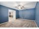 Blue bedroom with carpeted floors, a ceiling fan, and an open doorway to another room at 19248 Searay Dr, Noblesville, IN 46060
