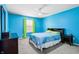 Vibrant bedroom featuring blue walls, neutral carpet, ceiling fan, and a window with light green curtains at 19248 Searay Dr, Noblesville, IN 46060