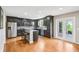 Modern kitchen with dark cabinetry, stainless steel appliances, granite counters, and hardwood floors at 19248 Searay Dr, Noblesville, IN 46060