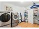 Well-lit laundry room with stainless steel washer and dryer and wooden floors at 19248 Searay Dr, Noblesville, IN 46060