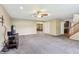 Bright living room featuring neutral carpeting, ceiling fan, and access to other living spaces at 19248 Searay Dr, Noblesville, IN 46060