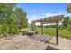 Spacious backyard with a hot tub under a pergola, large grassy area, and mature landscaping, creating a serene retreat at 19552 Wagon Trail Dr, Noblesville, IN 46060