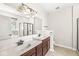 Bright bathroom featuring a double sink vanity, shower with glass door, tile flooring and large mirror at 19552 Wagon Trail Dr, Noblesville, IN 46060