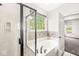 A relaxing bathroom featuring a soaking tub, a window, and a separate shower with glass door at 19552 Wagon Trail Dr, Noblesville, IN 46060
