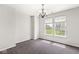Empty dining room featuring modern chandelier, plush carpet, and bright natural light at 19552 Wagon Trail Dr, Noblesville, IN 46060