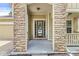 Covered front porch featuring stone columns and a stylish multi-pane glass front door, creating a welcoming entrance at 19552 Wagon Trail Dr, Noblesville, IN 46060