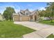 Charming home featuring a stone and siding exterior, an attached three car garage, and lush lawn at 19552 Wagon Trail Dr, Noblesville, IN 46060