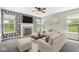 Sun-filled living room has white furniture, fireplace, mounted TV and patterned accent wall at 19552 Wagon Trail Dr, Noblesville, IN 46060