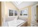 Bright bathroom featuring a soaking tub under a skylight and a large window with a beautiful outdoor view at 2001 E Ely Ct, Martinsville, IN 46151