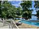 Stunning pool with lakeside views, surrounded by mature trees and a deck with outdoor seating at 2001 E Ely Ct, Martinsville, IN 46151