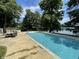 Stunning pool with lakeside views, surrounded by mature trees and a deck with outdoor seating at 2001 E Ely Ct, Martinsville, IN 46151