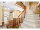Elegant staircase featuring wooden railings, carpeted steps, and stone accent wall; a beautiful focal point at 2001 E Ely Ct, Martinsville, IN 46151