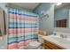 Bright bathroom featuring a white sink and toilet, and a colorful striped shower curtain at 2125 Jason Dr, Lebanon, IN 46052