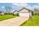 The house has a concrete driveway leading to a two-car garage, complemented by a well-manicured lawn at 2125 Jason Dr, Lebanon, IN 46052
