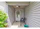 A well-lit, covered porch with a chair and decor welcomes you at the front door of this inviting home at 2125 Jason Dr, Lebanon, IN 46052