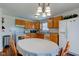 Bright kitchen with white appliances, wood cabinets and flooring, and chandelier at 2125 Jason Dr, Lebanon, IN 46052
