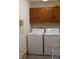 Laundry room features front load washer and dryer, oak cabinets, and white walls at 215 Fairway Ct, Franklin, IN 46131
