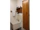 Utility sink with oak towel rack, shelf with products, and light colored walls at 215 Fairway Ct, Franklin, IN 46131