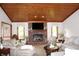 Spacious living room with a cozy brick fireplace, wood-paneled ceiling, and ample seating at 215 Fairway Ct, Franklin, IN 46131
