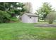 Backyard shed in a green yard and pine trees offers convenient storage space for tools and equipment at 215 Fairway Ct, Franklin, IN 46131