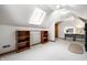 An attic space with carpet, shelving, desk, lighted mirror, and a skylight provides ample usable space at 225 Yorkshire E Blvd, Indianapolis, IN 46229