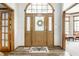 Inviting foyer features a decorative glass door, wood floors, and views into other rooms at 225 Yorkshire E Blvd, Indianapolis, IN 46229