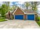 Attached two car garage doors colored a bright blue provides ample parking and storage at 225 Yorkshire E Blvd, Indianapolis, IN 46229