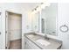 Bathroom featuring a double vanity with stone countertop, dual mirrors and a walk-in closet at 2418 Winthrop Ave, Indianapolis, IN 46205