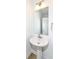 Modern powder room featuring a pedestal sink, a decorative mirror and wood look flooring at 2418 Winthrop Ave, Indianapolis, IN 46205
