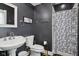 Chic bathroom with dark walls, modern fixtures, vanity, toilet, shower and stylish black and white shower curtain at 25 N Wayburn St, Indianapolis, IN 46229