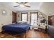 Comfortable bedroom with hardwood floors, a ceiling fan, large windows, and vintage-style furniture at 25 N Wayburn St, Indianapolis, IN 46229
